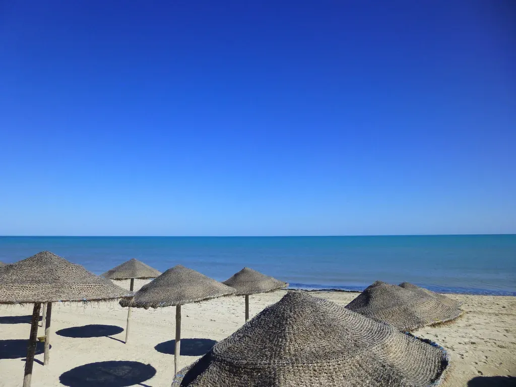 Plage djerba parasols — illustration de l'article « Djerbahood, l'incroyable aventure de Mehdi Ben Cheikh »