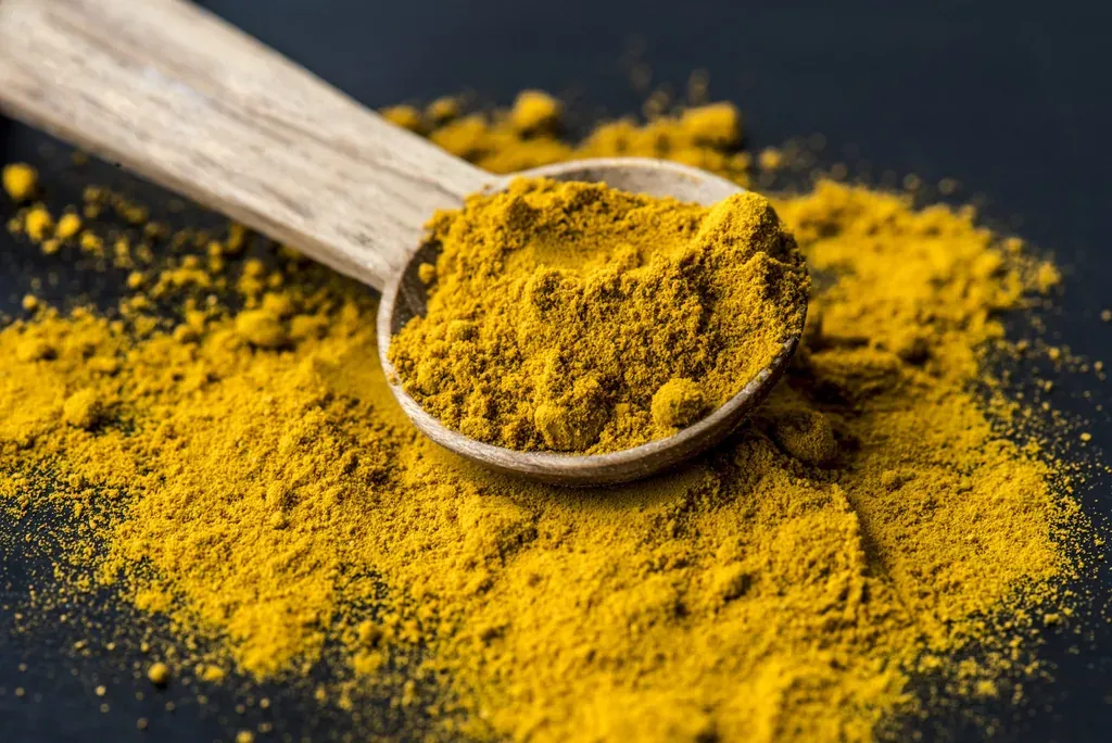 Curcuma cuillere bois — illustration de l'article « Pâte au curcuma pour soulager les gencives »
