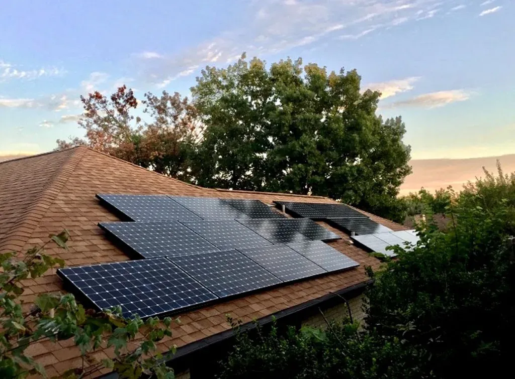 Panneaux solaires photovoltaïques installés sur le toit en pente d'une maison au crépuscule