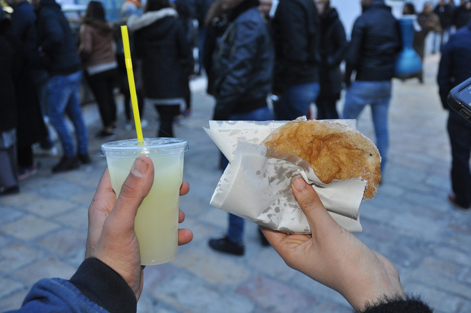 Bambalouni sucré et citronnade à la main dans une rue tunisienne