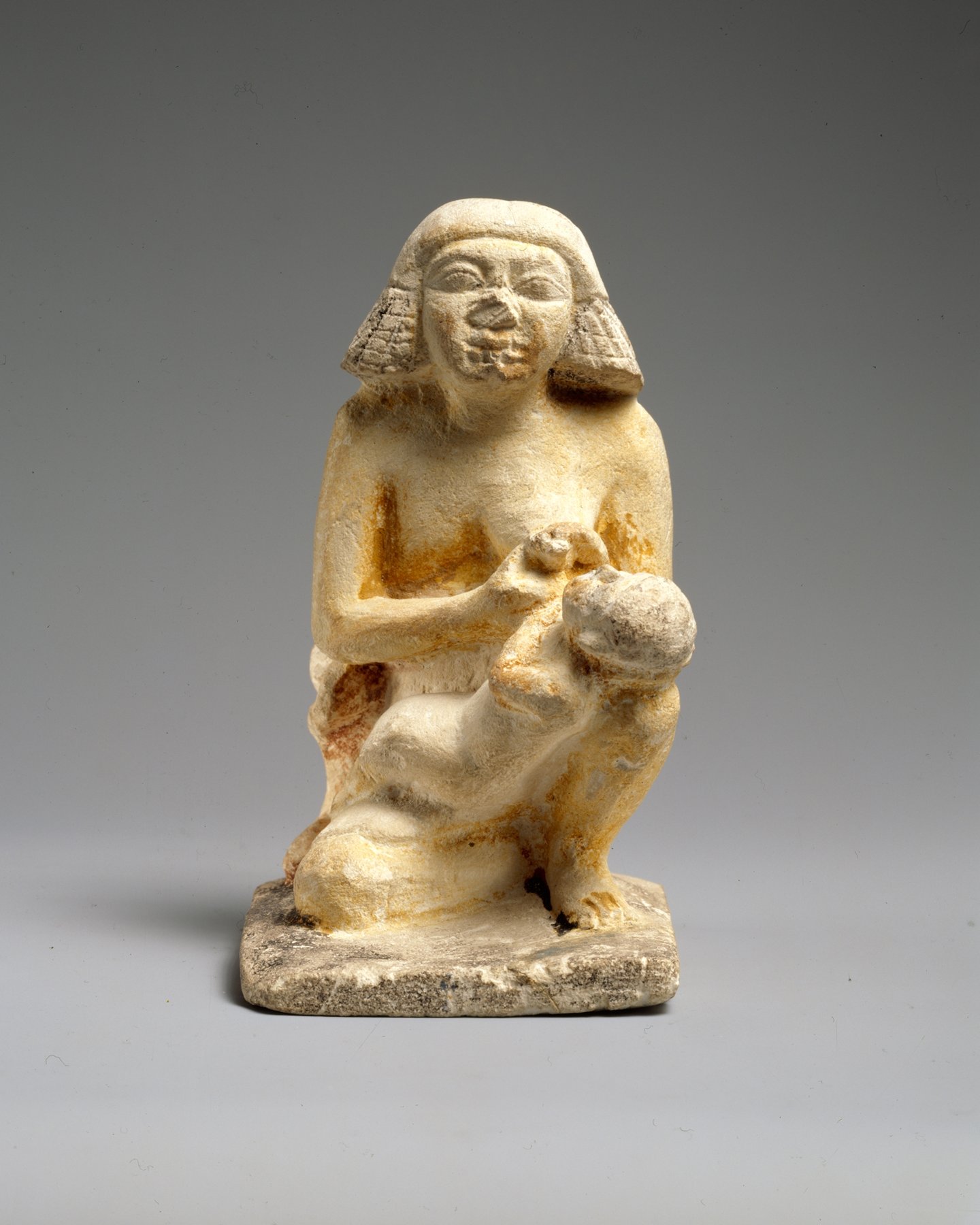 Statuette égyptienne ancienne d'une femme tenant tendrement un enfant contre elle