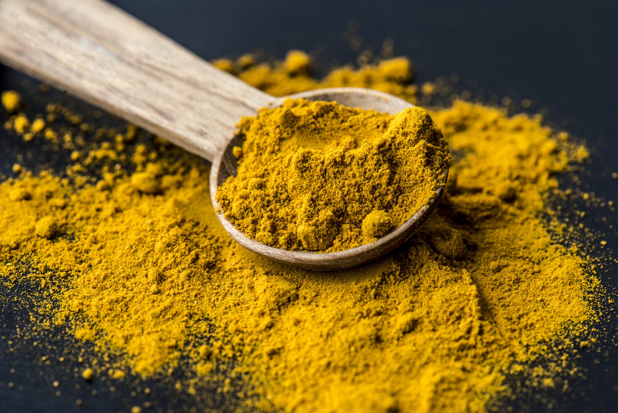 Curcuma cuillere bois — illustration de l'article « Pâte au curcuma pour soulager les gencives »